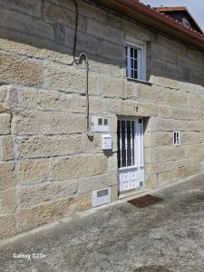 un edificio de ladrillo con una puerta blanca y una ventana en Casa Lina VUT OR 000784, en Allariz