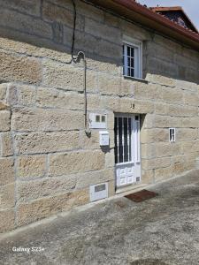 a brick building with a white door and a window at Casa Lina VUT OR 000784 in Allariz