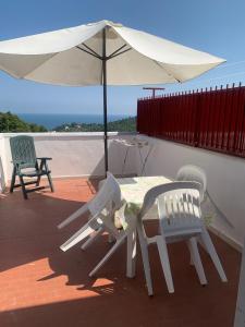 a table and chairs and an umbrella on a patio at Villa Pineta in San Menaio