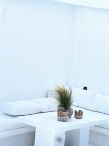 a white coffee table with a potted plant on it at Sunsenses villa Ariadne in Piso Livadi