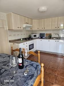 cocina con mesa y botella de vino en Casa Lina VUT OR 000784, en Allariz 17 fotos más