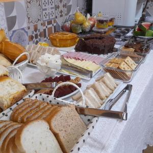 uma mesa com pão e outros alimentos em Pousada Benedicta em Aparecida