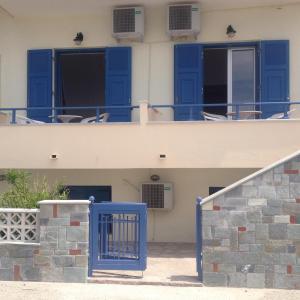 a blue gate in front of a building with blue doors at Hotel Kyma in Skala Eresou