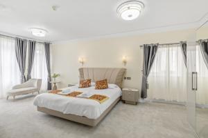 um quarto branco com uma cama grande e uma cadeira em The Drake Hotel Plymouth em Plymouth
