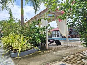 un complejo con una hamaca, plantas y una piscina en Garden Village Resort en Moalboal