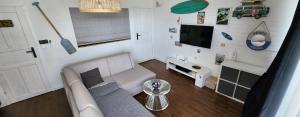 a living room with a couch and a tv at Apartament Mechelinki, wysoki standard. in Pierwoszyno +7 photos