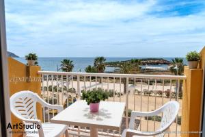 a balcony with a table and chairs and the beach at Primera línea de mar en Isla Plana in Isla Plana