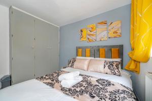 a bedroom with a bed and two paintings on the wall at *F6GH For your most relaxed & cosy stay + FREE PARKING & WiFi in Bramley