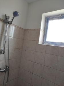 a shower in a bathroom with a window at Casa Laranja Santa Maria in Santa Maria