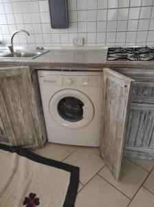 a washing machine in a kitchen with a sink at Casa Laranja Santa Maria in Santa Maria
