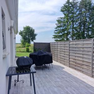 a patio with three chairs and a fence at Maison meublée de la Varenne in Pannes