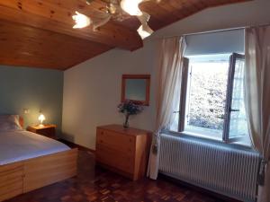 Schlafzimmer mit einem Bett und einem Fenster in der Unterkunft Casa Gina in Roana