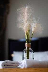 a glass vase with feathers in it on a table at Goethe House in old town Zürich in Zurich