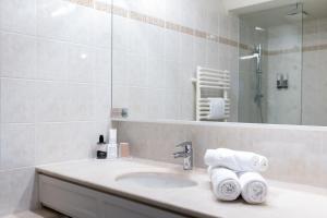 W łazience znajduje się umywalka, lustro i ręczniki. w obiekcie Le Relais Saint Michel w mieście Mont Saint-Michel
