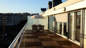 a balcony with a table and an umbrella at OASIS in Buarcos