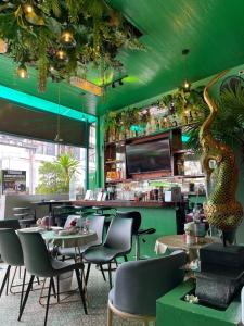 a restaurant with green walls and tables and chairs at Elephant Room in Patong Beach