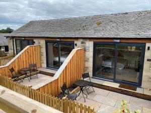 una casa con terraza con sillas y mesas en The Star Inn - Harbottle - Near Rothbury - Northumberland en Morpeth