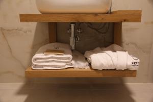 ein Regal mit Handtüchern und einem Waschbecken im Bad in der Unterkunft Kruja Albergo Diffuso , Inside Kruja Castle in Kruja
