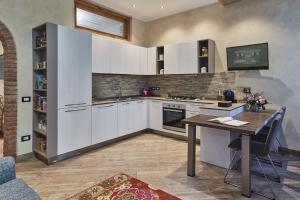 kuchnia z białymi szafkami i drewnianym stołem w obiekcie Cà Zanna Traditional Design Apartment w mieście Treviso +10 zdjęć