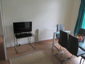 a living room with a glass table and a television at Cheerful well presented 3 Bedroom period house in Forest Hill