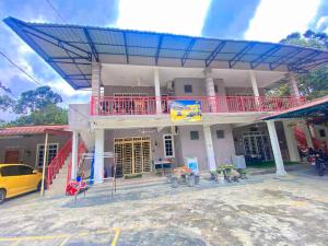 una casa con techo azul y coche amarillo en Homestay Zalida D Musleem en Kampong Alor Gajah