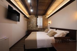 a bedroom with a bed with a television and a table at Kruja Albergo Diffuso , Inside Kruja Castle in Krujë