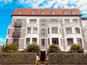 a large white building with a red roof at Gatsby Hotel - Adults Only - Restaurant - Small Luxury Hotel by F-Hotels in Blankenberge