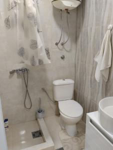 een badkamer met een toilet, een douche en een wastafel bij HM Apartmani in Bar