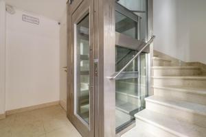 a glass elevator in a building with stairs at Ca' San Carlo Residence by Wonderful Italy in Venice