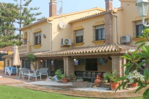 a house with a patio and a table and chairs at Casa Beatriz in Rincón de la Victoria