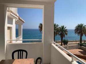 a balcony with a table and a view of the ocean at Fuentes de Nerja in Nerja