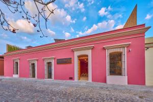 un bâtiment rose avec une cloche au-dessus dans l'établissement City Centro by Marriott Oaxaca, à Oaxaca
