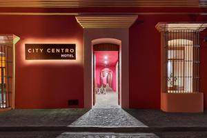 a hallway with red walls and a sign that reads city centre hotel at City Centro by Marriott Oaxaca in Oaxaca City