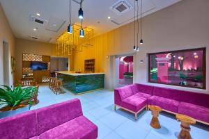 a living room with purple couches and a bar at City Centro by Marriott Oaxaca in Oaxaca City