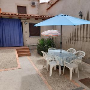 una mesa y sillas con una sombrilla azul en Casa Rural La Jara, en Botija