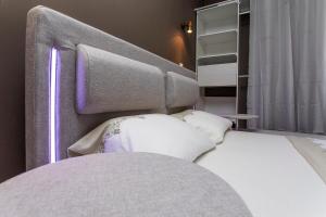 1 dormitorio con cama blanca y cabecero en BLUE HOME, en Roanne