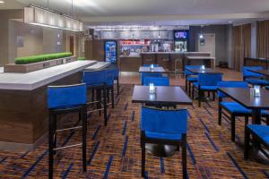 um restaurante com cadeiras e mesas azuis e um bar em Courtyard by Marriott Albany em Albany
