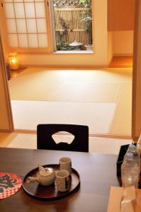 een keuken met een tafel met kopjes en een raam bij harper house in Osaka