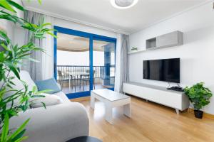 uma sala de estar com um sofá e uma televisão em ApartUP Patacona Surfing Beach em Valência
