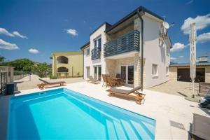 a large swimming pool in front of a house at Apartmani Drage in Drage
