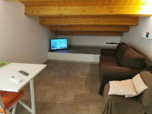 un soggiorno con divano e TV di La Mansarda Iblea a Palazzolo Acreide