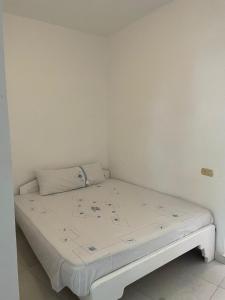 Cama pequeña en habitación con paredes blancas en Cabin 8 studio, en Dahab