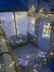 a patio with christmas lights and a table and chairs at Caretaker’s Cottage 