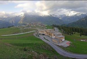 Ein Gebäude auf einem Feld mit Bergen im Hintergrund in der Unterkunft Samoens 1600, Grand Massif in Samoëns