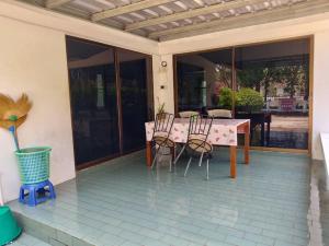 un patio con tavolo e sedie su una casa di 2-bed house near beach w/ aircon a Ban Krut