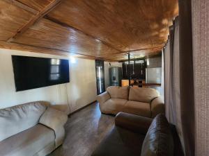 a living room with two couches and a flat screen tv at Lunar Garden Villa in Maun