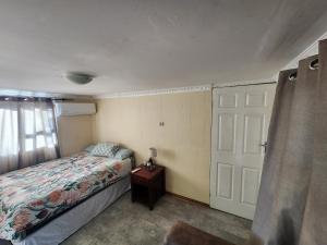 1 dormitorio con cama y puerta en Lunar Garden Villa, en Maun