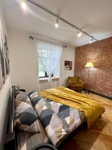 a bedroom with a bed and a brick wall at Art Apartment Glebova in Lviv