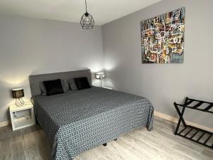 a bedroom with a bed and a painting on the wall at Maison centre Lamotte Beuvron in Lamotte-Beuvron