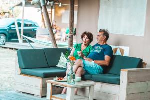 Glamping Holten luxe safaritent 1 في هولتين: رجل وامرأة يجلسون على الأريكة